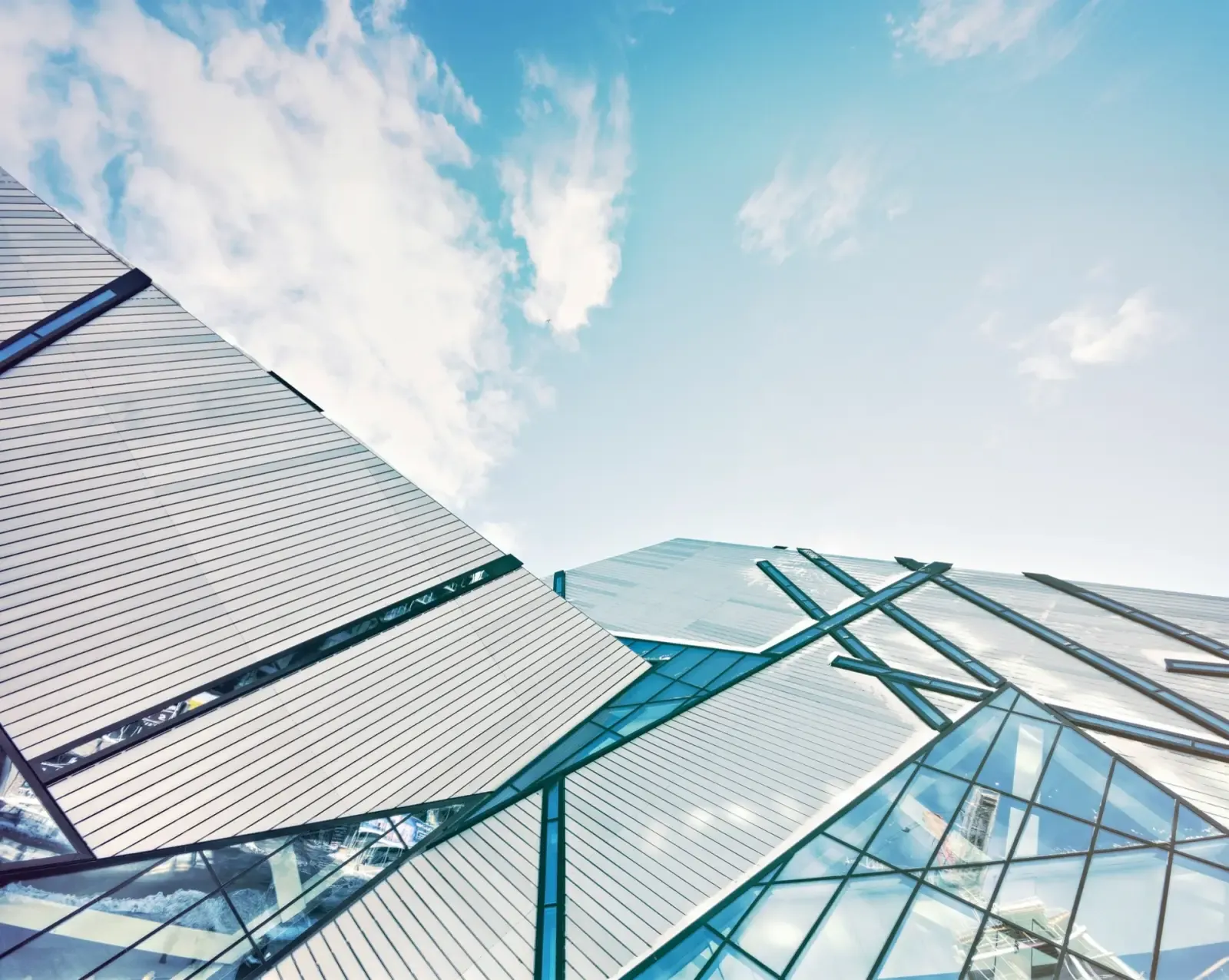 Angular glass-and-steel building facade against a bright sky